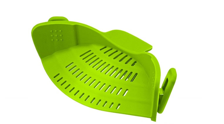 Green plastic strainer on a white background